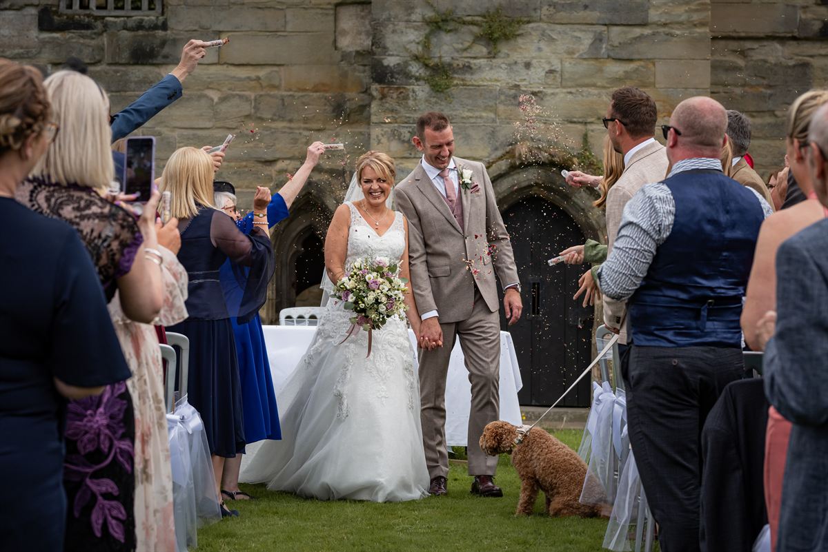 Wedding party celebrating with confetti outside church